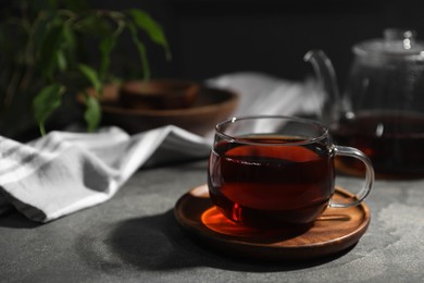 Tasty hot tea in cup on grey table, closeup. Space for text