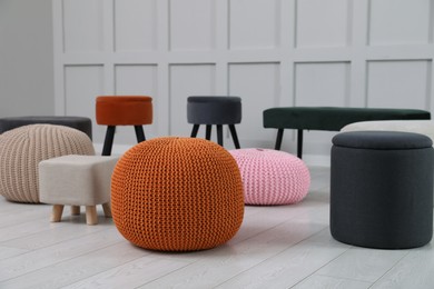 Photo of Different stylish poufs and ottomans in room