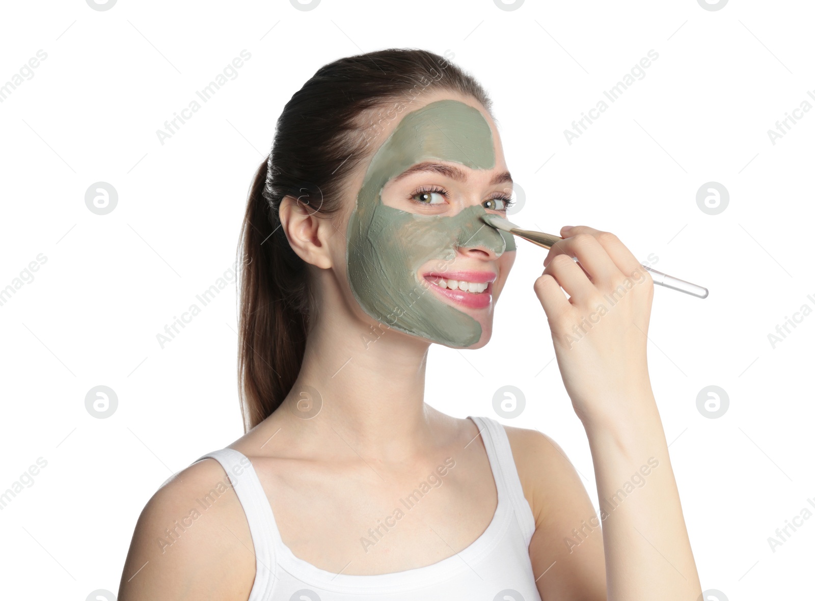 Photo of Young woman applying clay mask on her face against white background. Skin care