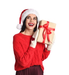 Woman in Santa hat, knitted mittens and red sweater holding Christmas gift on white background