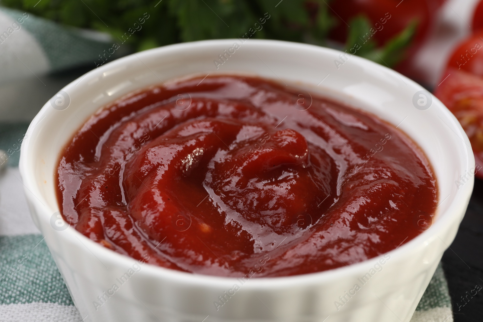 Photo of Organic ketchup in bowl on table, closeup. Tomato sauce