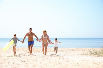 Photo of Family with inflatable ring at beach on sunny day