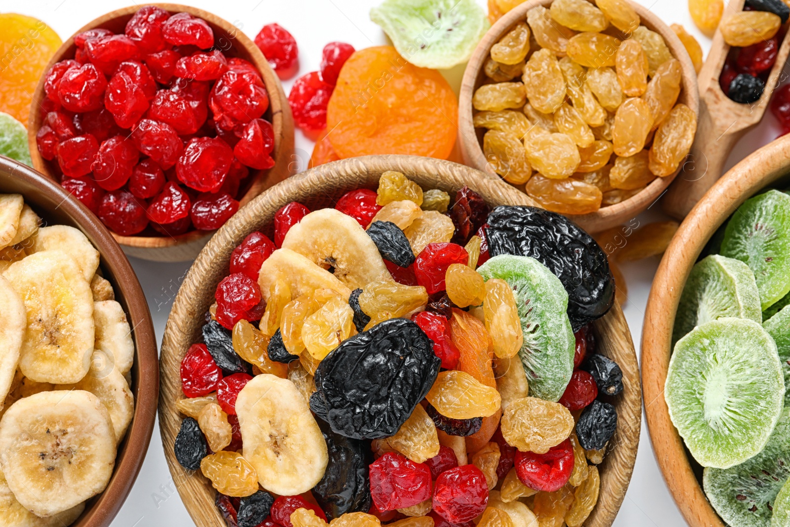 Photo of Bowls with different dried fruits on white  background, flat lay. Healthy lifestyle