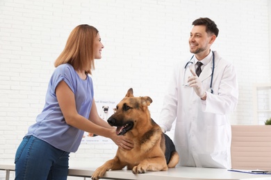 Photo of Woman with her dog visiting veterinarian in clinic