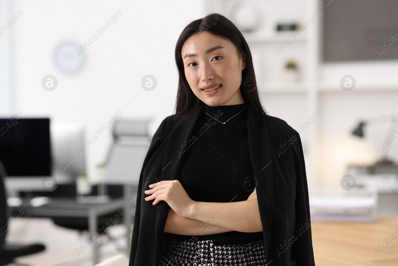 Photo of Portrait of smiling businesswoman with crossed arms in office