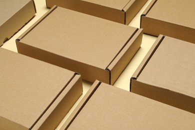 Photo of Many closed cardboard boxes on pale yellow background, closeup