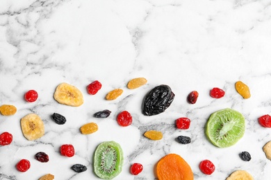 Photo of Different dried fruits on marble background, top view with space for text. Healthy lifestyle