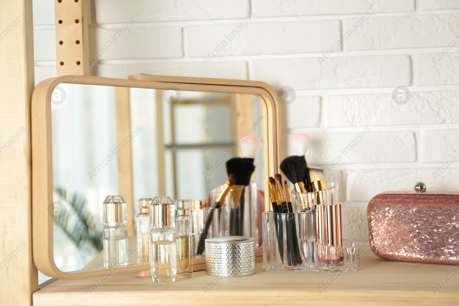 Photo of Perfumes and makeup products on dressing table