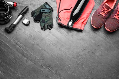 Flat lay composition with different cycling accessories on grey background, space for text