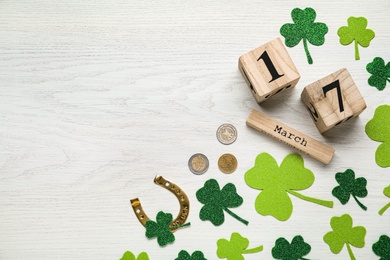 Flat lay composition with block calendar on white wooden table, space for text. Saint Patrick's Day celebration