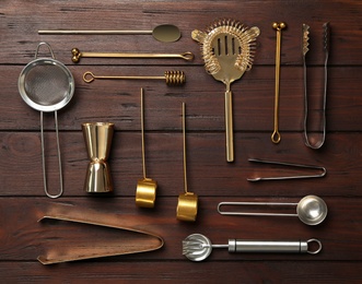 Set of modern cooking utensils on brown wooden table, flat lay