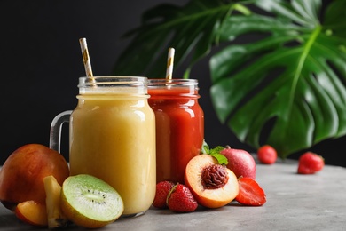 Photo of Delicious juices and fresh ingredients on grey table