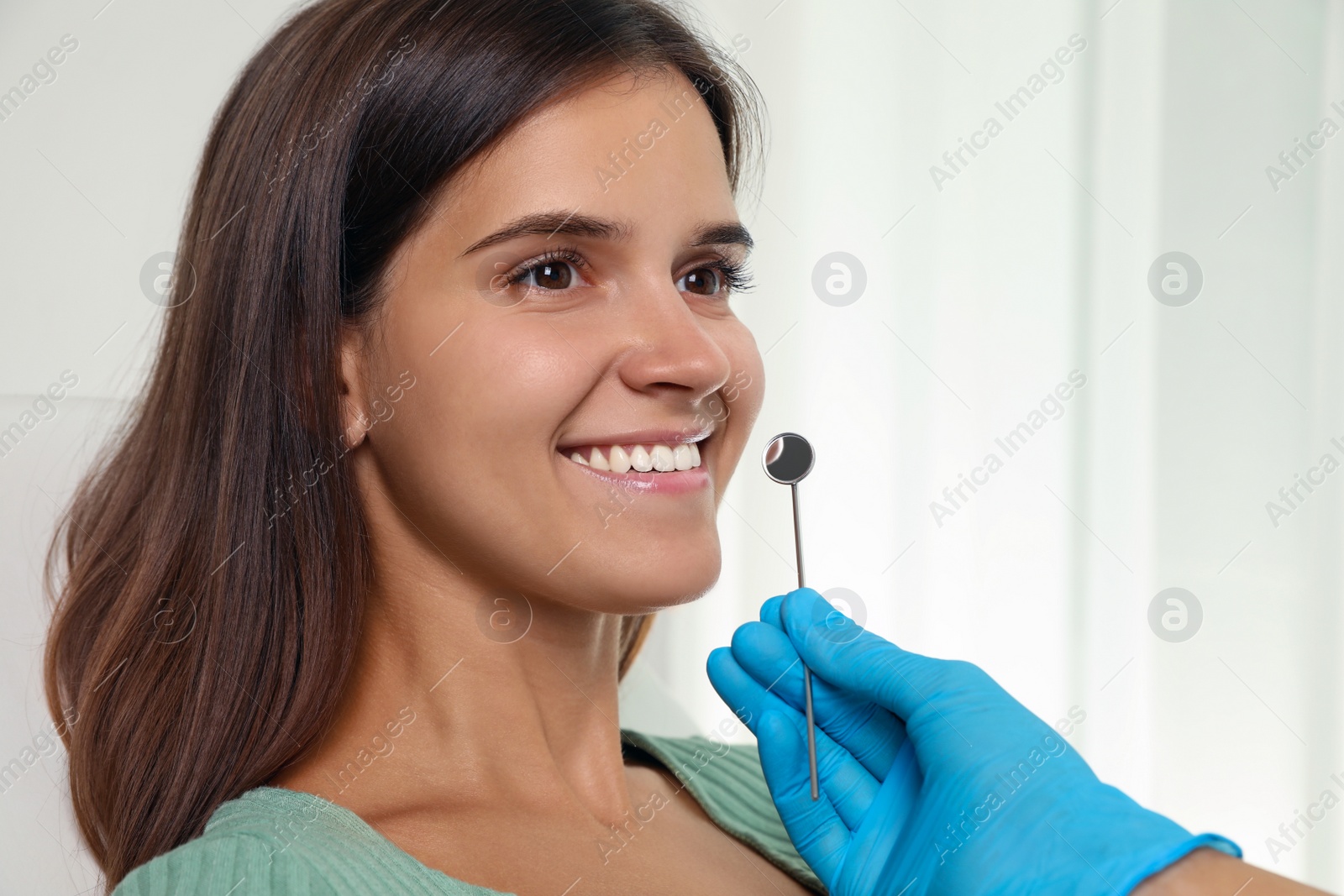 Photo of Dentist examining patient's teeth in modern clinic. Cosmetic dentistry