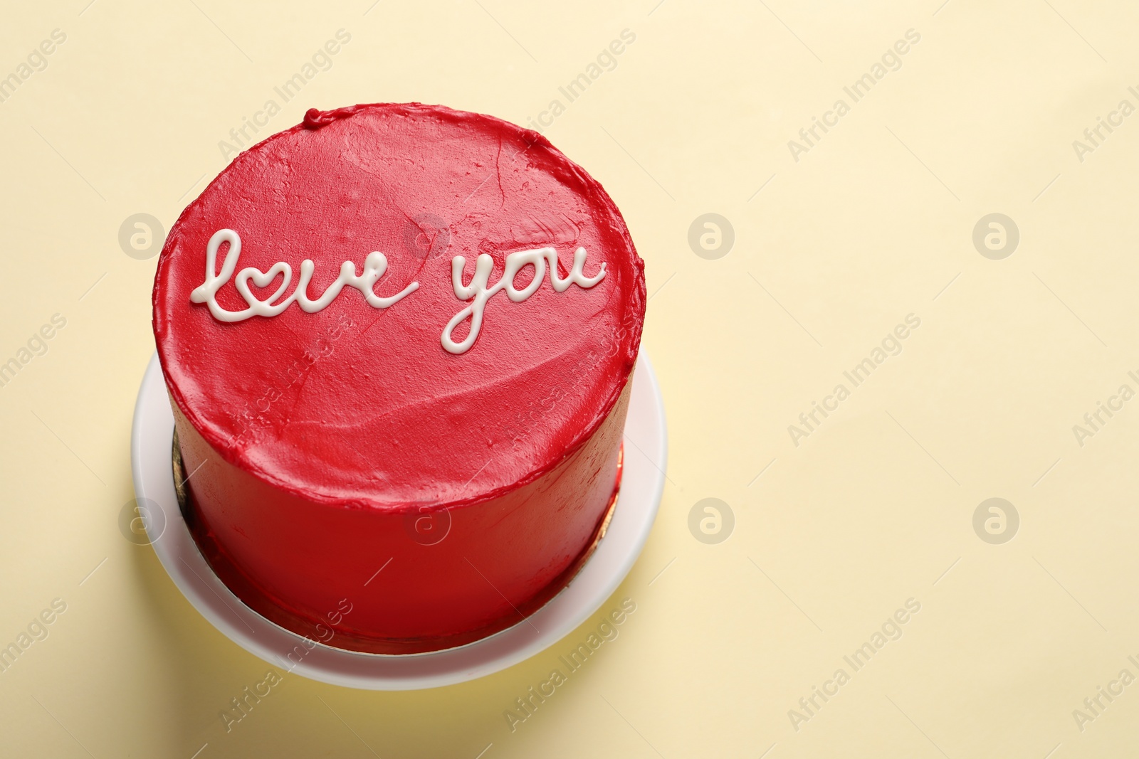 Photo of Bento cake with text Love You on beige table, space for text. St. Valentine's day surprise