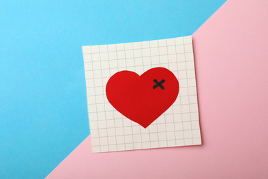 Paper with drawn heart on color background, top view. Relationship problems concept
