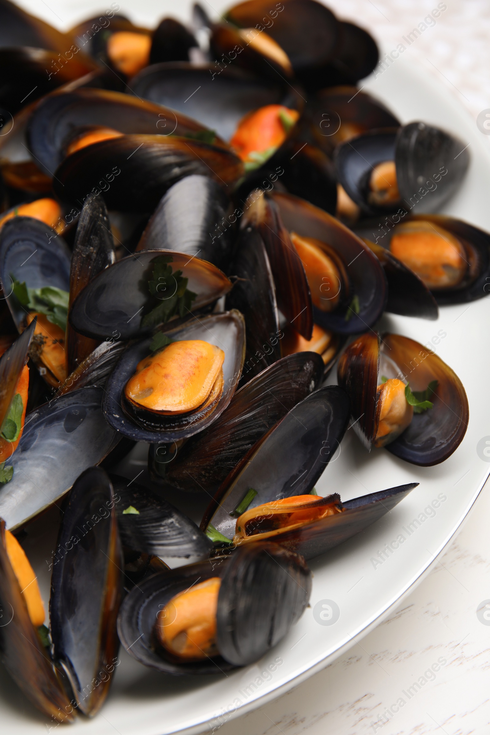 Photo of Plate of cooked mussels with parsley, closeup