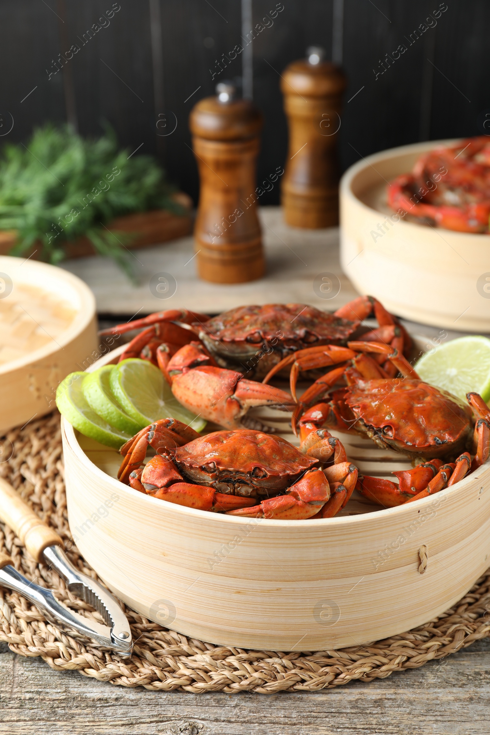 Photo of Delicious boiled crabs with lime and dill served on wooden table