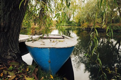 Light blue wooden boat on lake near pier