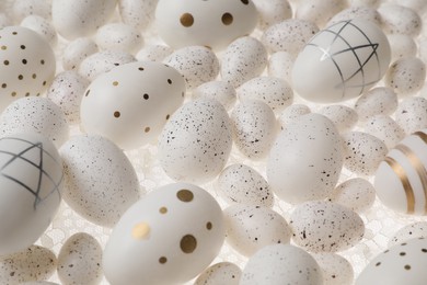 Photo of Many painted Easter eggs on white lace fabric