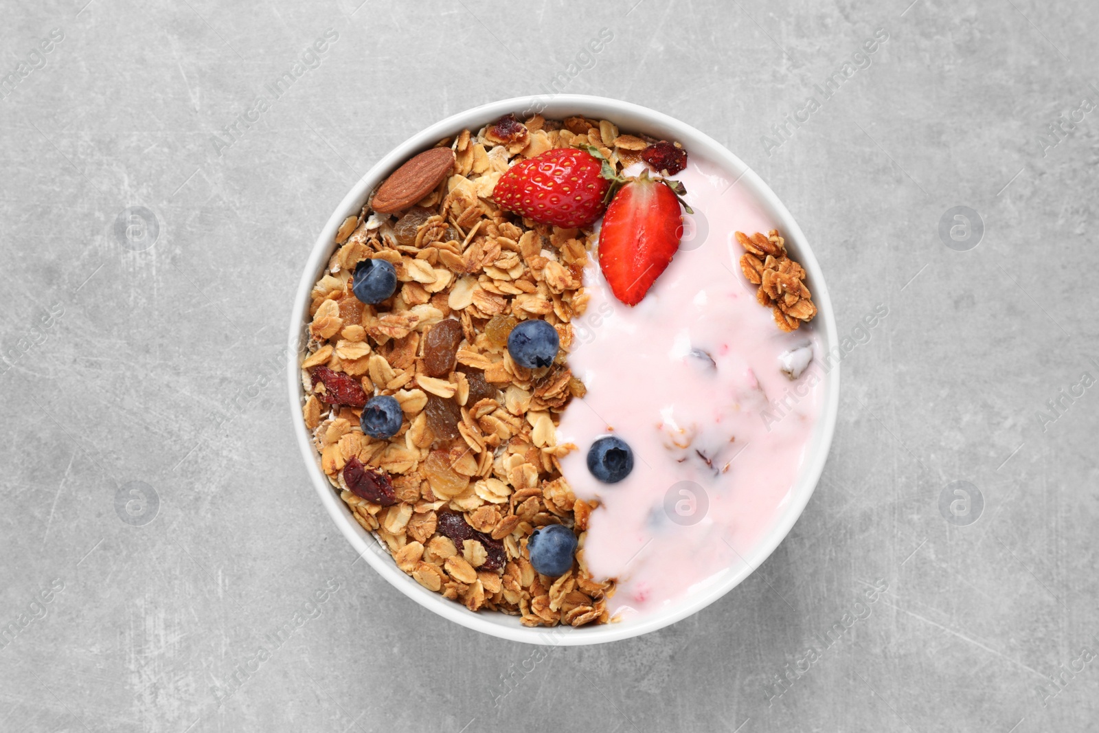 Photo of Tasty homemade granola served  on grey table, top view. Healthy breakfast