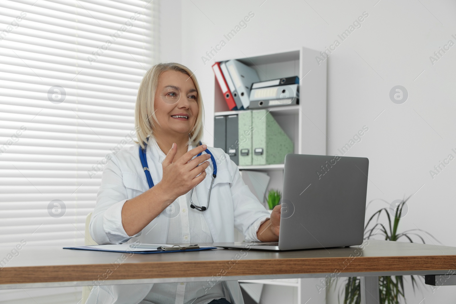 Photo of Doctor sitting at wooden table in clinic