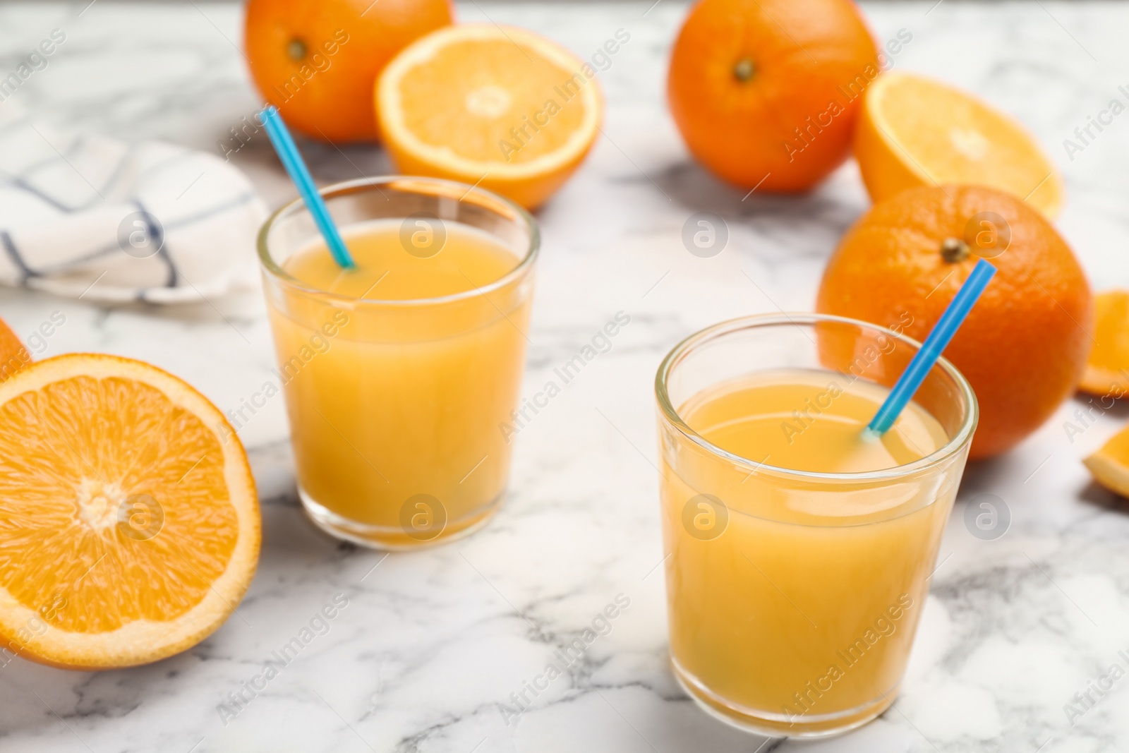 Photo of Delicious orange juice and fresh fruits on white marble table