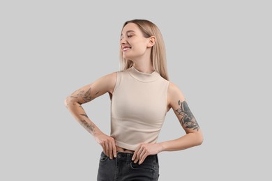 Portrait of beautiful tattooed woman on gray background