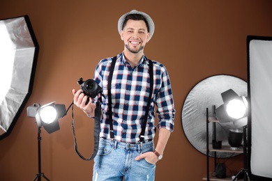Photo of Professional photographer with camera and lighting equipment in studio