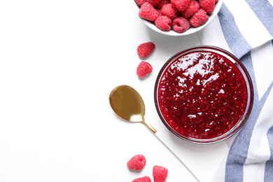 Delicious jam and fresh raspberries on white table, flat lay. Space for text