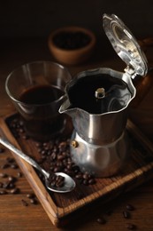 Brewed coffee, moka pot and beans on wooden table