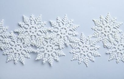 Photo of Beautiful snowflakes on white background, flat lay