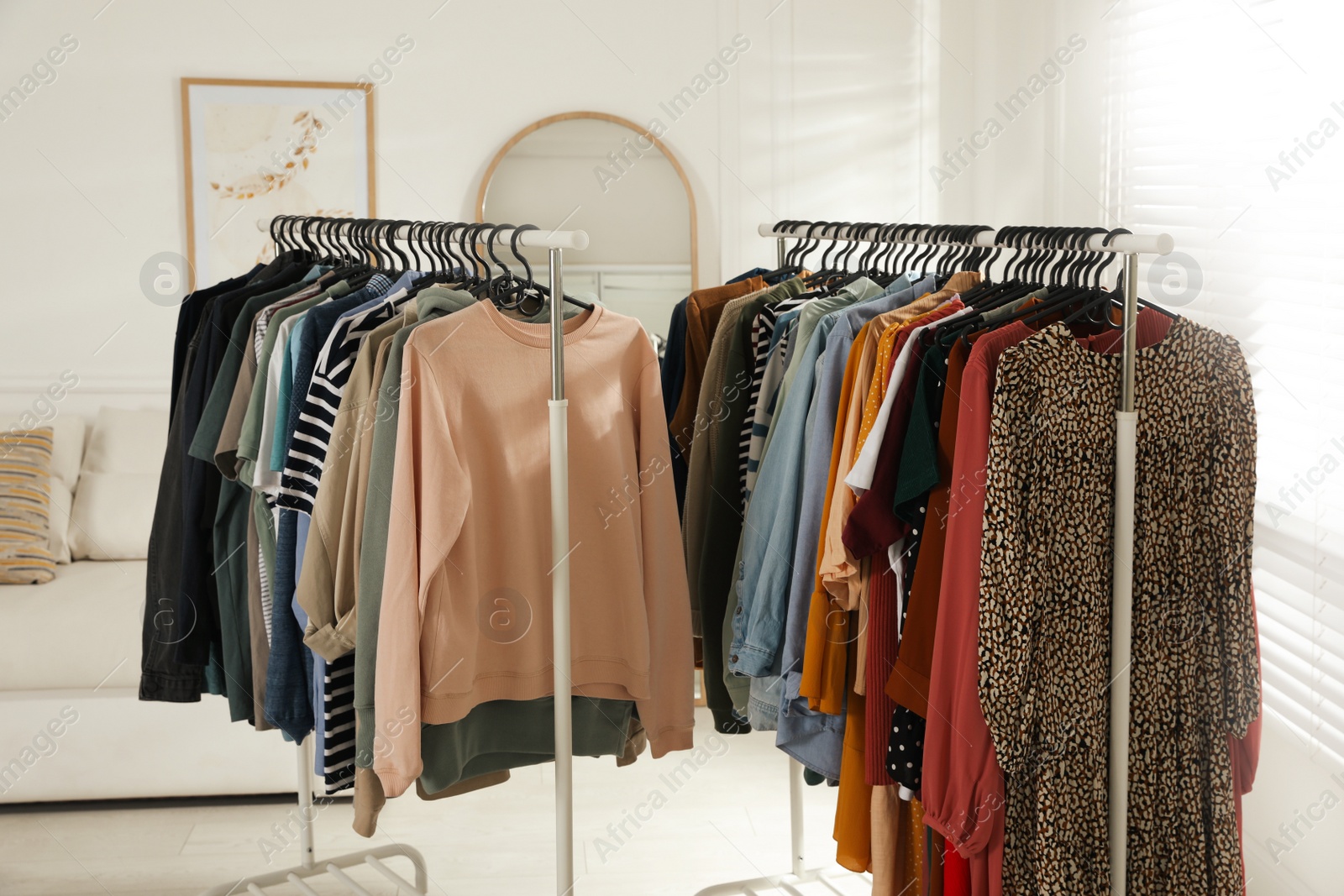 Photo of Racks with stylish clothes indoors. Fast fashion