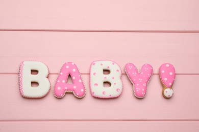 Photo of Word BABY made of tasty cookies on pink wooden table, flat lay