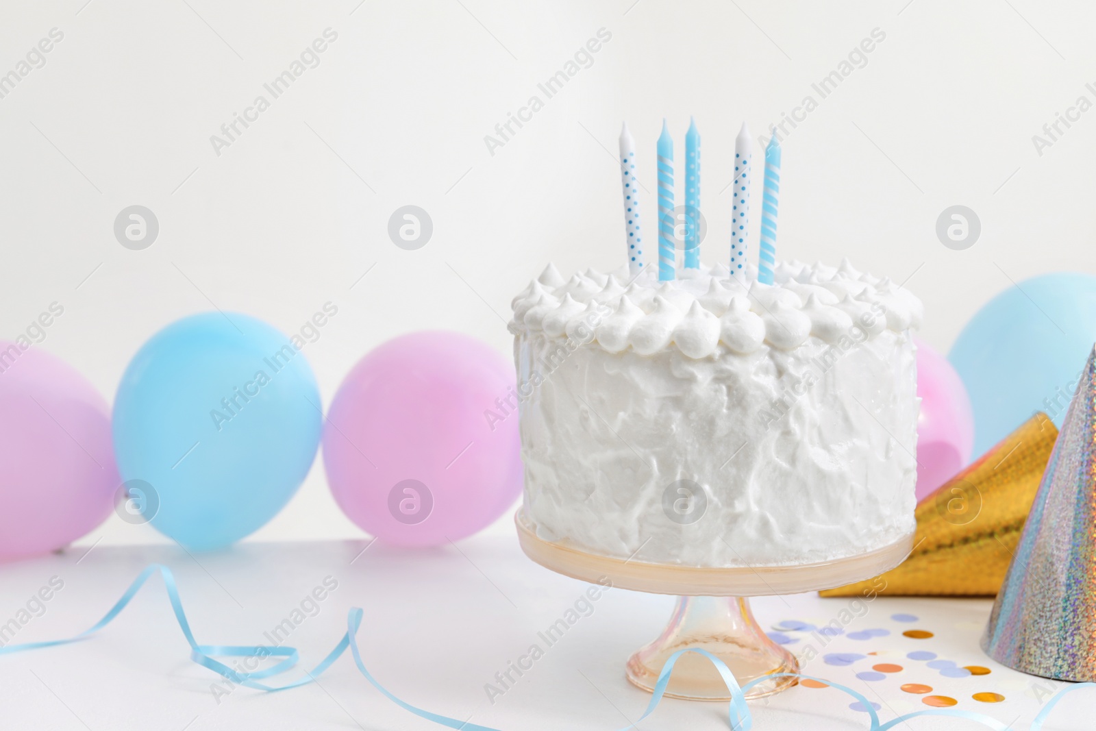 Photo of Delicious cake with candles and decorations on white table. Space for text