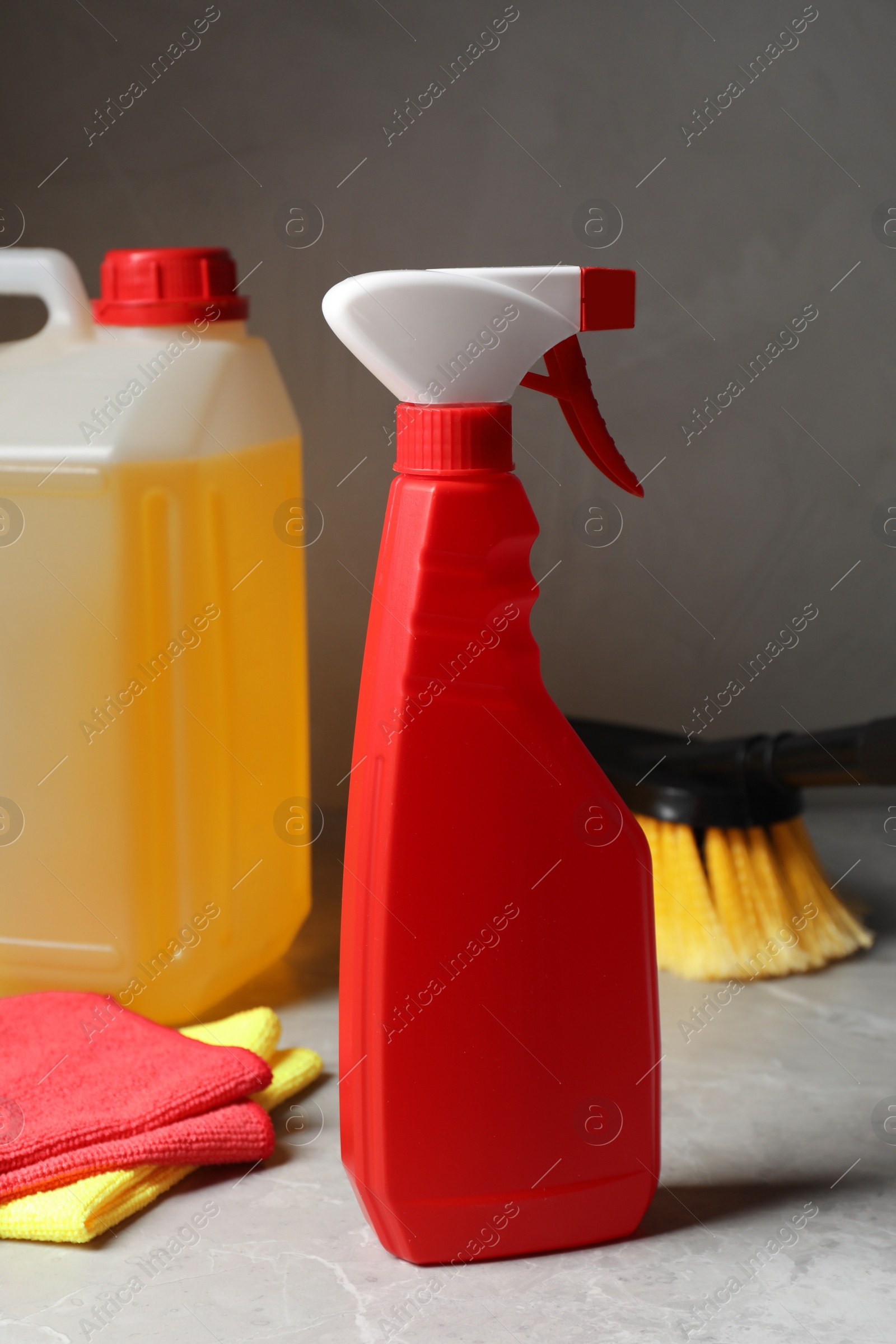 Photo of Car cleaning products and canister with motor oil on light grey table