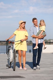 Happy family with bicycle outdoors on sunny day