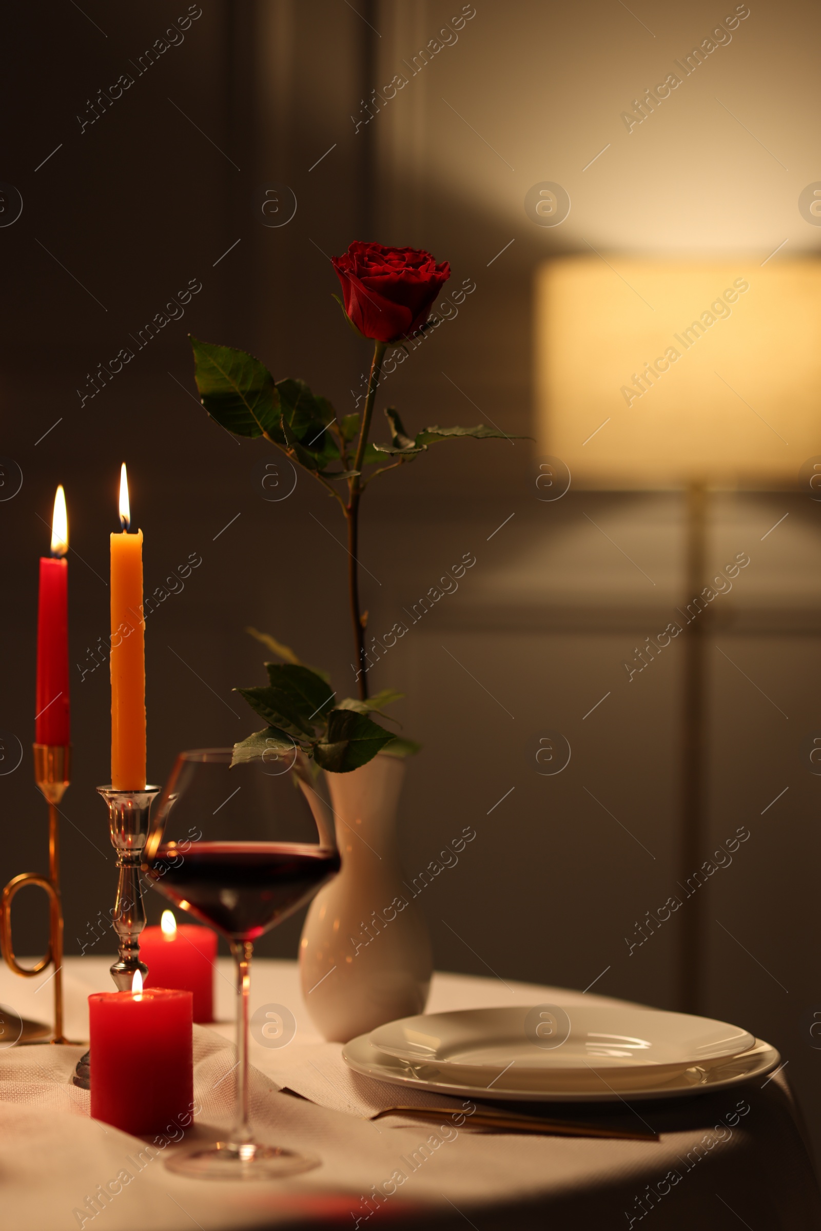 Photo of Elegant table setting with burning candles in restaurant