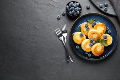Delicious cottage cheese pancakes with blueberries on black table, flat lay. Space for text