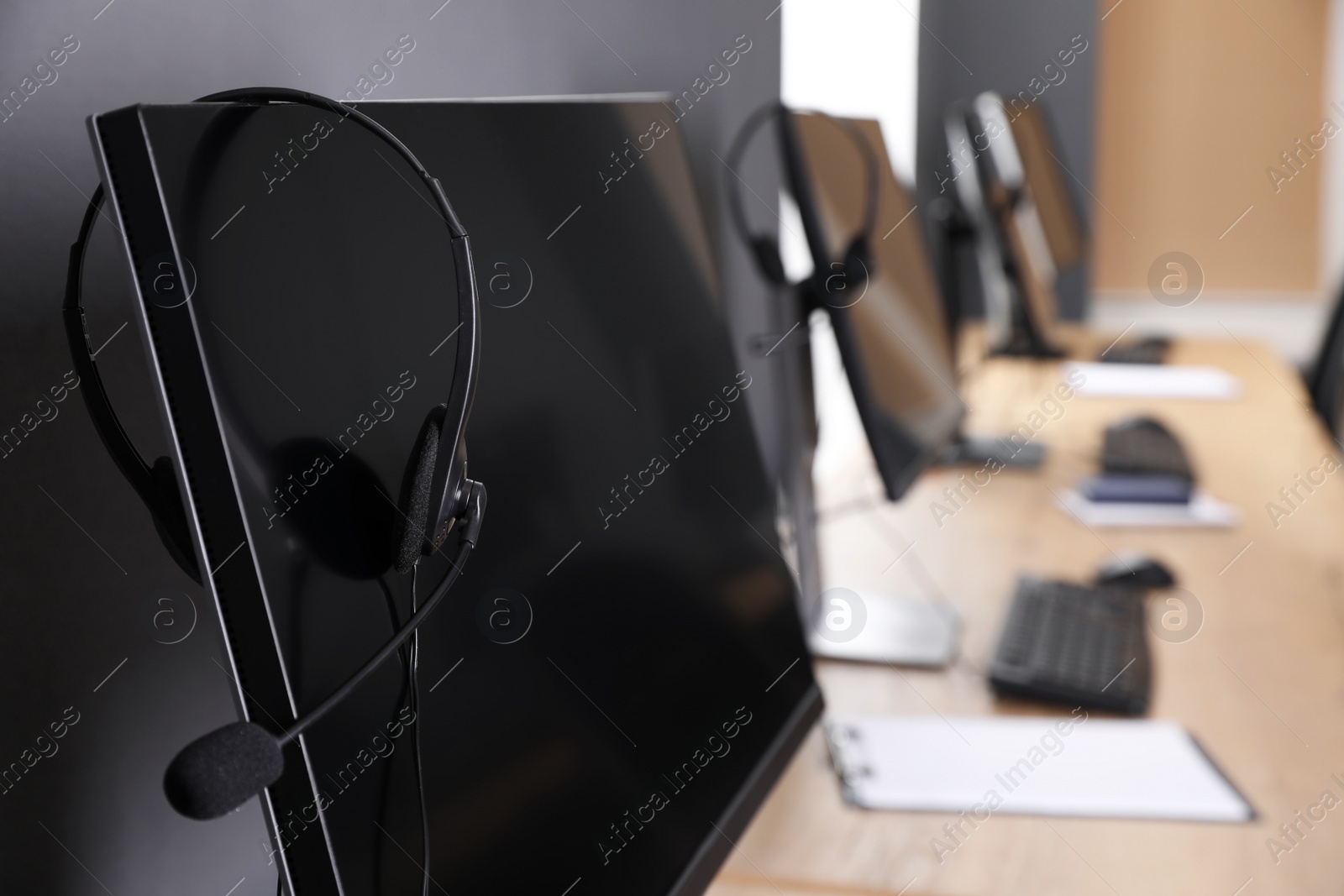 Photo of Modern computer with headset in office. Hotline service