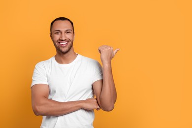 Portrait of happy African American man on orange background. Space for text