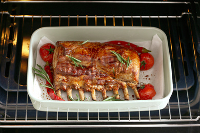 Delicious roasted ribs with tomatoes in oven