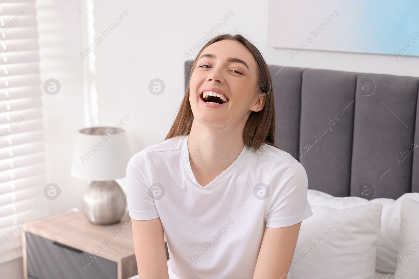 Photo of Portrait of beautiful woman laughing in bedroom