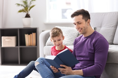 Dad and his son reading book at home