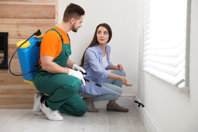 Photo of Woman showing insect traces to pest control worker at home