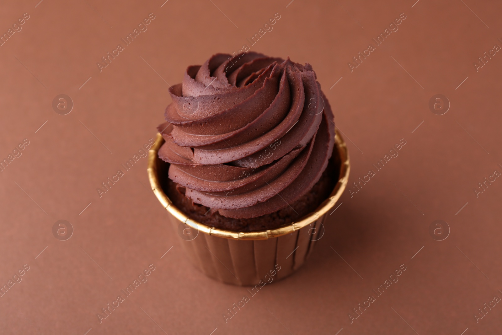 Photo of Delicious chocolate cupcake on brown background, closeup