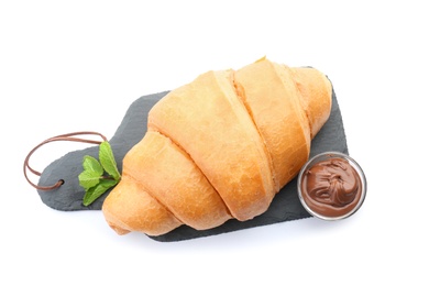 Photo of Slate plate with tasty croissant and chocolate sauce on white background