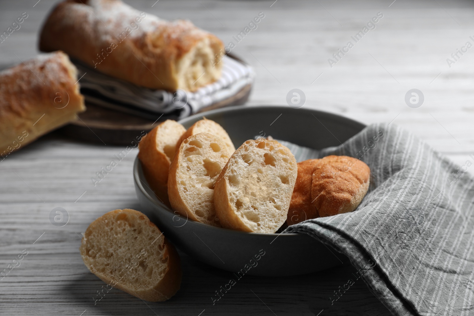 Photo of Fresh crispy ciabattas on white wooden table. Space for text