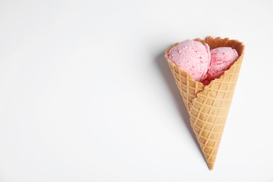 Delicious ice cream in wafer cone on white background, top view