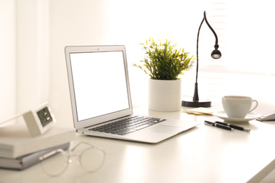 Photo of Modern laptop on office table. Stylish workplace