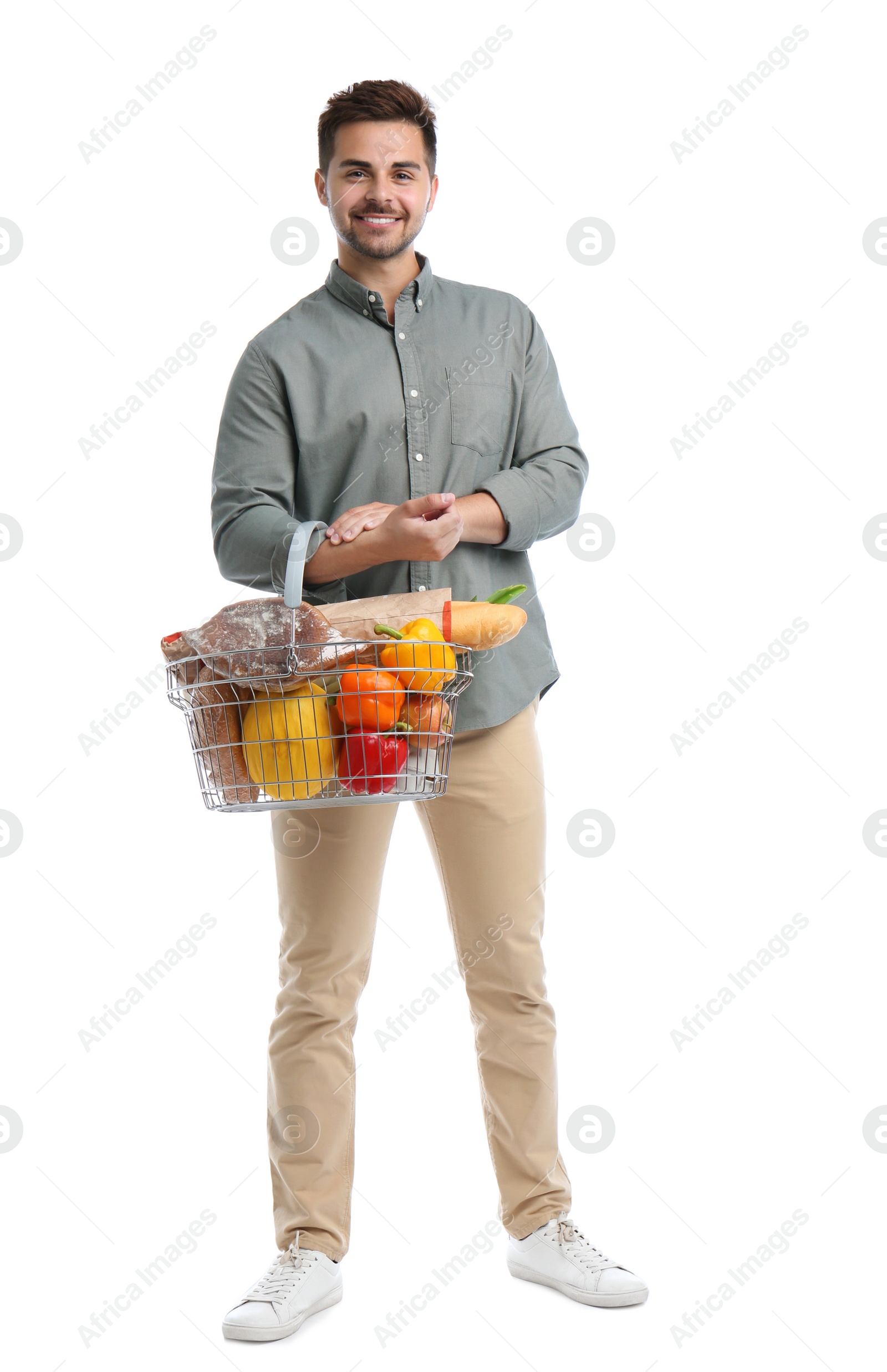 Photo of Young man with shopping basket full of products isolated on white